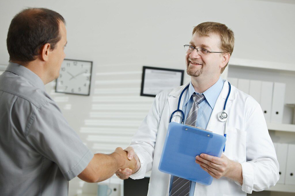 A spine surgeon explaining an MRI report to a patient during a consultation in Pune.